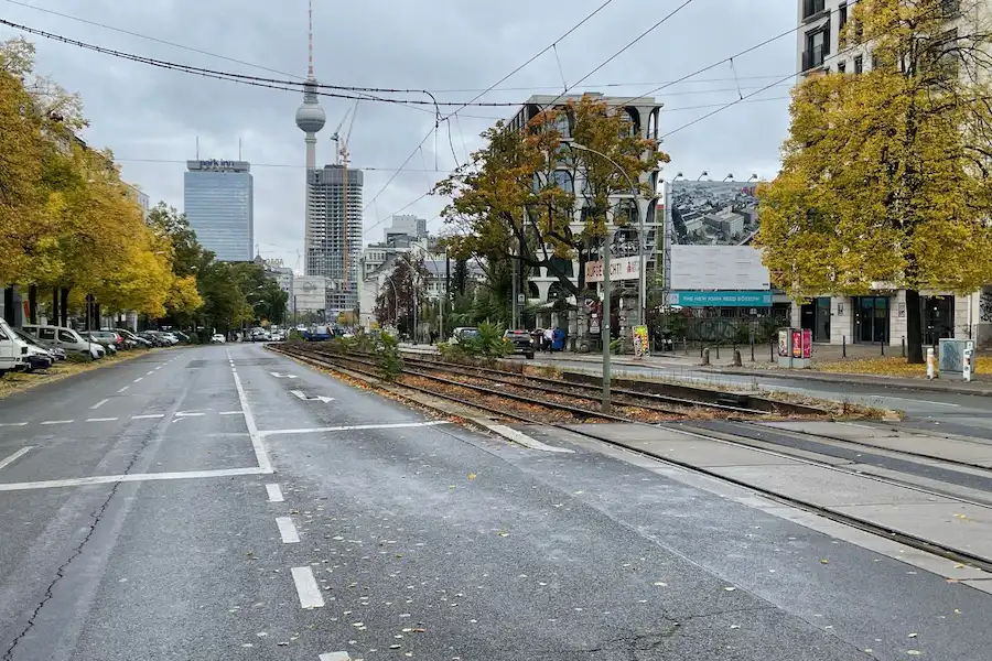 Prenzlauer Allee mit Tram-Haltestelle M2 und Blick auf den Fernsehturm – Anfahrt zur Praxis für Osteopathie Harald Erb