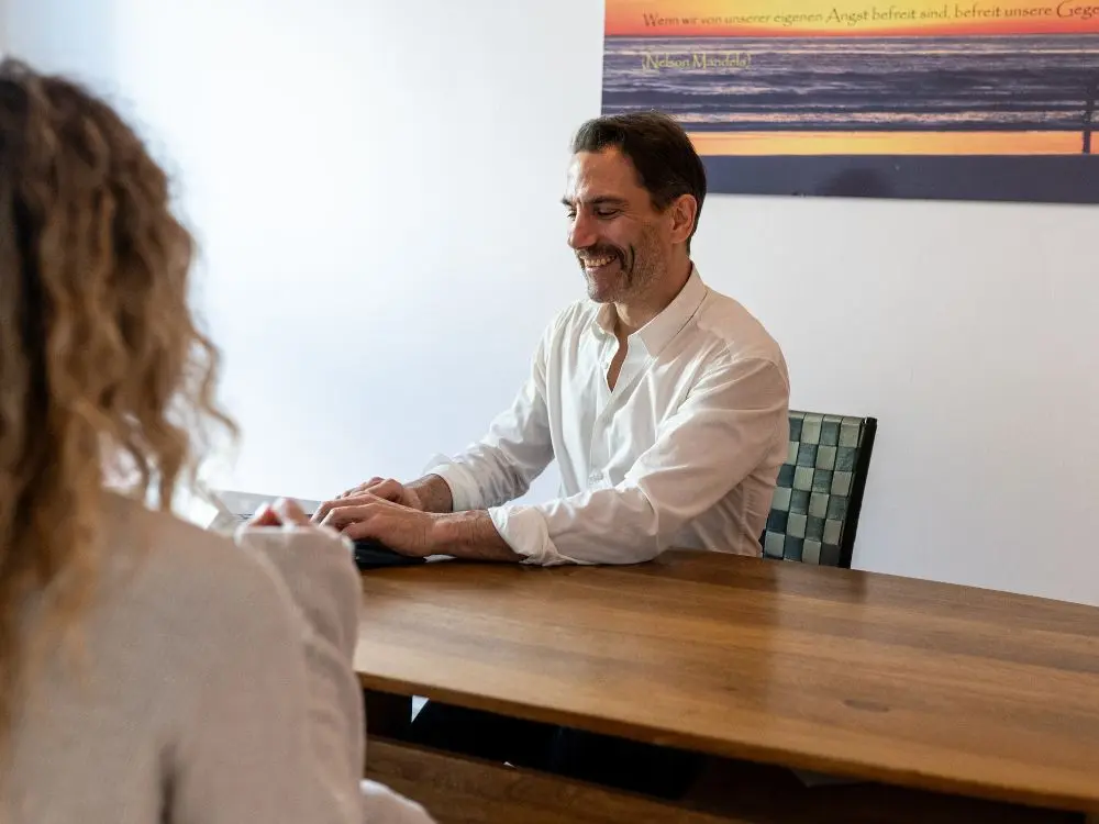 Harald Erb im Gespräch mit einem Patienten vor der Hexenschuss-Behandlung – Praxis im Kollwitzkiez, Berlin Prenzlauer Berg