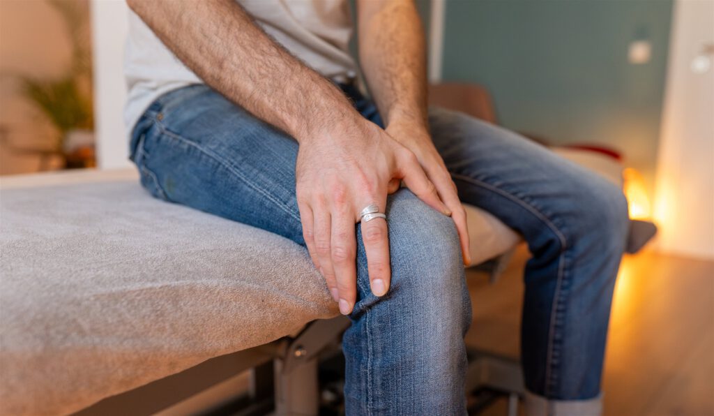 Schleimbeutelentzündung: Patient hält sich das schmerzende Knie – Osteopathie bei Harald Erb, Berlin Prenzlauer Berg